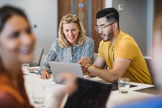 coworkers looking at laptop